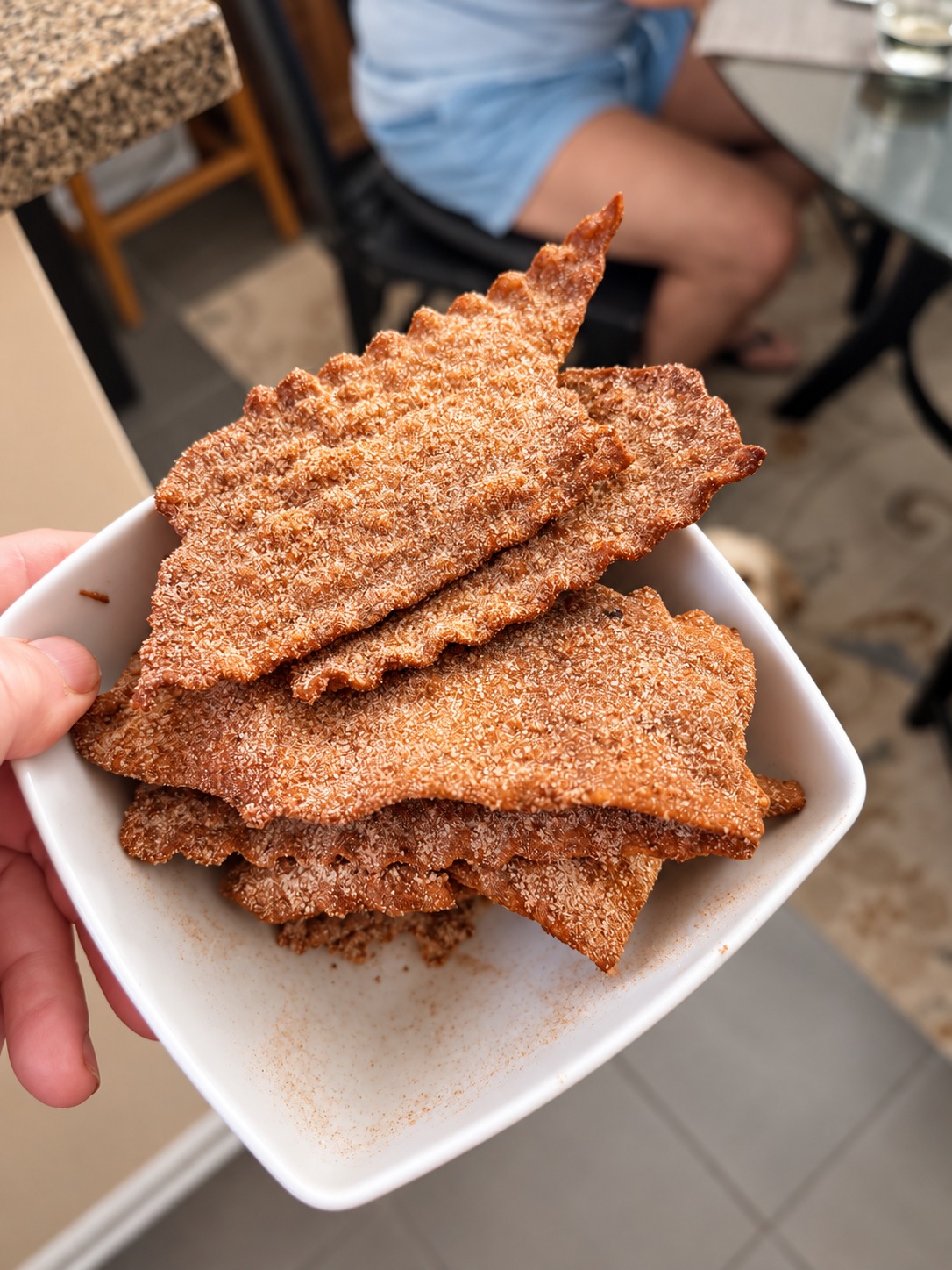 Freshly fried lasagna chips coated with cinnamon sugar in a white bowl